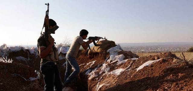 مقاتل من الجيش الحر يقف على أحد الخطوط الأمامية لمعسكر وادي الضيف في ريف إدلب الجنوبي.  رويترز