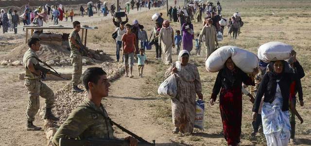 سوريون أكراد يعبرون الحدود إلى تركيا بعد سيطرة «داعش» على 24 قرية كردية.  أ.ف.ب