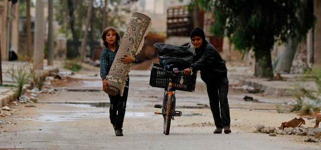 صبيان سوريان في أحد شوارع حلب المهجورة. رويترز
