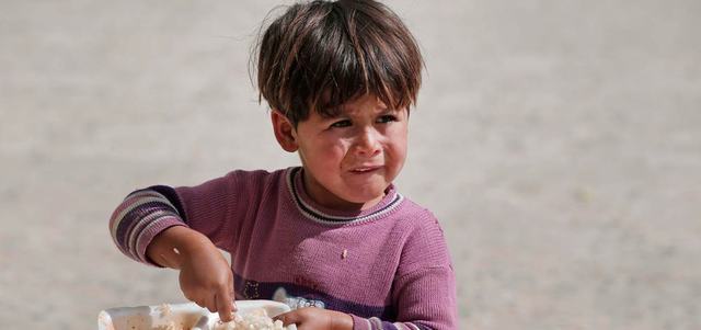 طفلة سورية كردية فرّت مع عائلتها من عين العرب.. تأكل طعاماً حصلت عليه من أحد المساجد على الحدود مع تركيا. أ.ب
