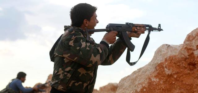 مقاتل من الجيش السوري الحرّ يطلق النار خلال اشتباكات مع القوات النظامية في منطقة حندرات بريف حلب. رويترز