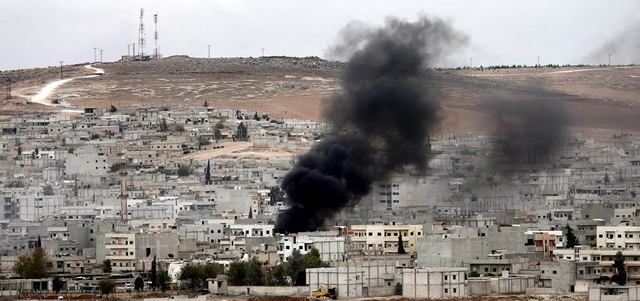 سحابة من الدخان الأسود في سماء عين العرب (كوباني) نتيجة القتال والقصف.   إي.بي.إيه