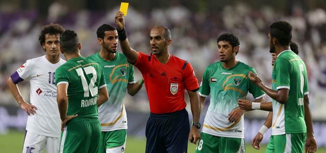 الحكم عادل النقبي يرفع البطاقة الصفراء في وجه لاعب الإمارات رودريغو. تصوير: إريك أرازاس