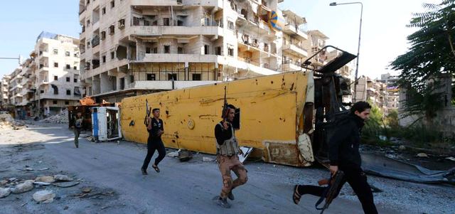 مقاتلون من المعارضة يحاولون تجنب القناصة عند خط المواجهة مع القوات النظامية في حي بستان الباشا بحلب. رويترز