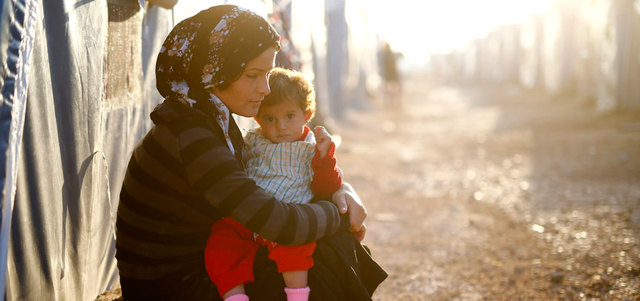 لاجئة سورية كردية من عين العرب تحتضن طفلتها في مخيم ببلدة سروج جنوب تركيا. رويترز