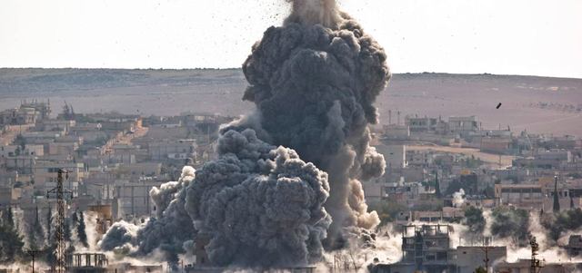 عمود من الدخان يرتفع في سماء عين العرب إثر غارة للتحالف على موقع لتنظيم «داعش» في المدينة. أ.ب