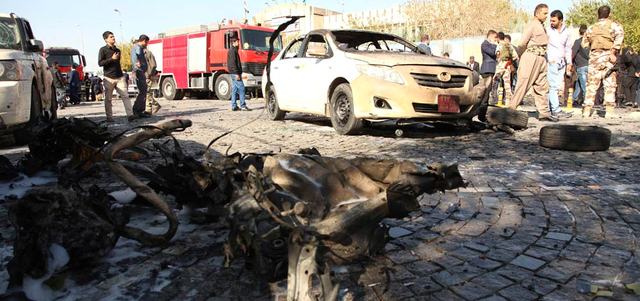 عناصر من قوات الأمن يتفقدون الأضرار الناجمة عن تفجير انتحاري بسيارة مفخخة استهدف مجلس محافظة أربيل. أ.ف.ب