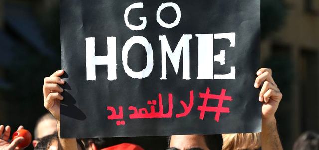 ناشط لبناني يرفع لافتة ضد التمديد. أ.ب