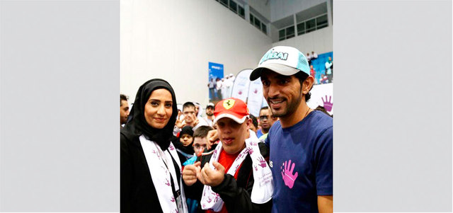 صورة تذكارية تجمع سموّ الشيخ حمدان بن محمد بن راشد مع سونيا الهاشمي ونجلها سيف خلال حضور سموّه بطولة ند الشبا الرياضية التي صادفت اليوم الرياضي لذوي «متلازمة داون».