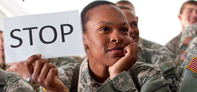 مجندة أميركية ترفع لافتة كتب عليها «قف» في إشارة لوقف التحرش الجنسي بالعاملات في الجيش الأميركي. أرشيفية