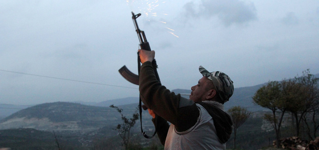 مقاتل من الجيش السوري الحر يطلق النار احتفالاً بزفاف زميل في منطقة جبل الأكراد بمحافظة اللاذقية. رويترز