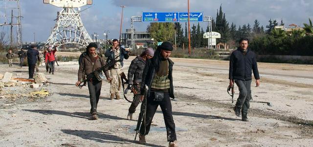 مقاتلو المعارضة يتجولون في معسكر الحامدية بعد أن  سيطروا عليه مع وادي الضيف بريف إدلب.  رويترز