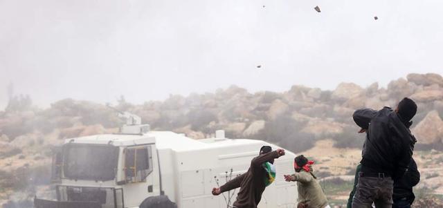 الفلسطينيون يواجهون قوات الاحتلال بالحجارة خلال مصادمات في رام الله.   أ.ف.ب