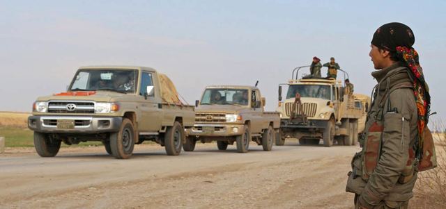 مركبات عسكرية كردية تمر من نقطة تفتيش تديرها «وحدات حماية الشعب» و«حزب العمال الكردستاني» على الطريق السريع شمال جبل سنجار. رويترز