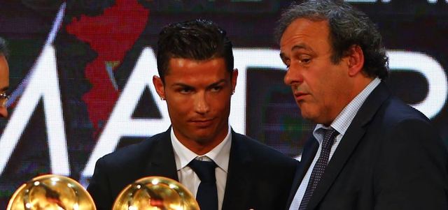 بلاتيني في حديث مع رونالدو على منصة تتويج اللاعب الأفضل في العالم بحفل جوائز «غلوب سوكر».     أ.ف.ب