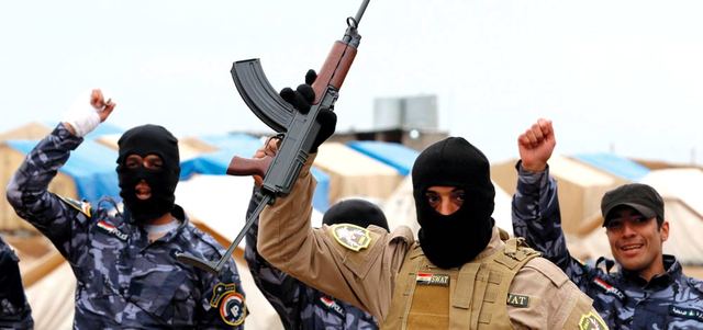 رجال شرطة من القوات الخاصة يهتفون خلال دورة تدريبية استعداداً لتحرير الموصل من «داعش».  أ.ف.ب