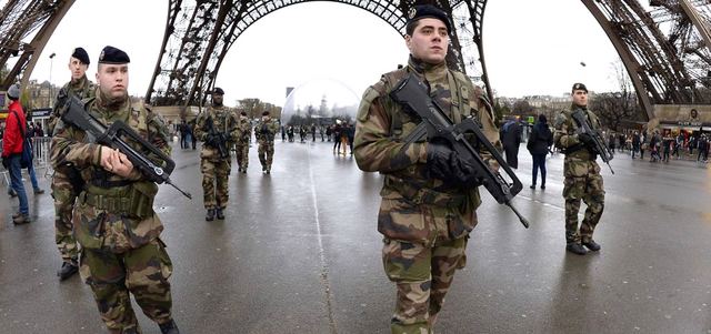 جنود فرنسيون خلال دوريات أمام برج إيفل في باريس عقب الإعلان عن نشر غير مسبوق للآلاف من قوات الجيش والشرطة لتعزيز الأمن في مواقع حساسة. أ.ف.ب