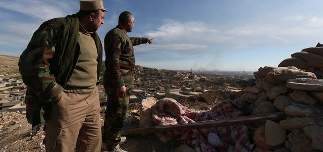 عنصر من البشمركة يشير إلى الأجزاء التي تسيطر عليها القوات الكردية ومناطق سيطرة «داعش».  أ.ب