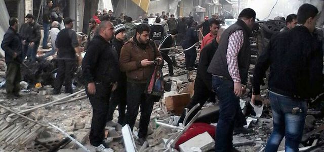 مدنيون يتفقدون الأضرار الناجمة عن انفجار سيارة مفخخة في حي عكرمة بحمص. أ.ب