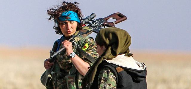مقاتلتان من وحدات حماية الشعب الكردي تحملان السلاح في الريف الغربي لمدينة رأس العين. رويترز