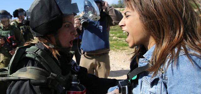 فلسطينية خلال مواجهة مع جندي إسرائيلي في بلعين.    أ.ف.ب