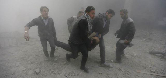 سكان يحملون رجلاً أصيب بغارات جوية للقوات النظامية على دوما قرب دمشق. رويترز