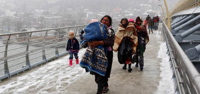 لاجئون سوريون يسيرون وسط البرد والثلوج للوصول إلى محطة المترو في إسطنبول.  رويترز