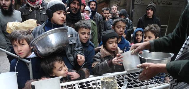 سكان من مخيم اليرموك للاجئين الفلسطينيين جنوب دمشق الذي تحاصره القوات النظامية يتلقون معونات غذائية في حي الجزيرة المجاور. أ.ف.ب