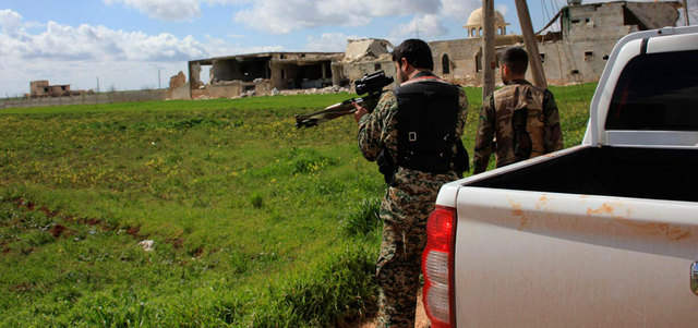 مقاتلان من القوات النظامية في قرية باشكوي بريف حلب بعد استعادتها من المعارضة.  رويترز