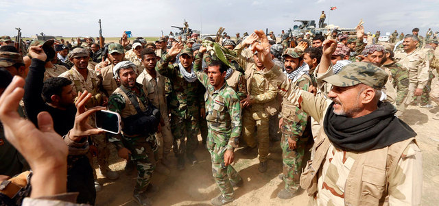 أفراد من قوات الأمن العراقية والمقاتلين الشيعة يحتفلون باستعادتهم السيطرة على بلدة حمرين من «داعش» في محافظة صلاح الدين. رويترز