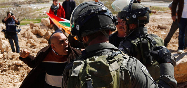 فلسطيني يحتد في وجه جندي إسرائيلي خلال مواجهات في بلدة أبودبس قرب القدس .   رويترز