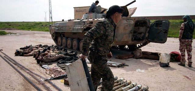مقاتلون أكراد يعرضون جثثاً لقتلى «داعش» وأسلحة غنموها خلال اشتباكات مع «التنظيم» في الريف الجنوبي من رأس العين. رويترز
