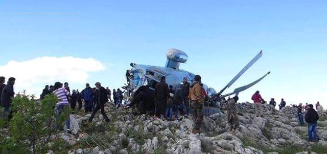 صورة للطائرة بعد إسقاطها.. وفي الإطار مسلحون يمسكون بأحد أفراد طاقمها.