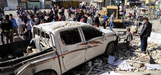 عراقيون يعاينون آثار انفجار سيارة مفخّخة في منطقة الحبيبية شرق بغداد.  أ.ب