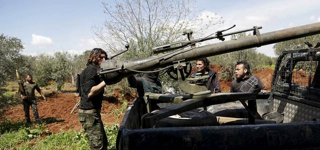 مقاتلون معارضون يجهّزون أسلحتهم قبل توجههم إلى خط الجبهة لمواجهة القوات النظامية في ريف إدلب. رويترز