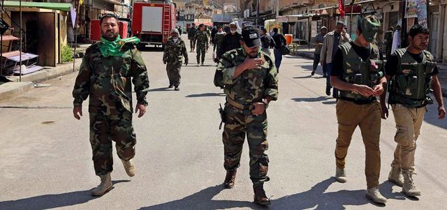 مقاتلون شيعة في أحد شوارع سامراء ينتظرون نقلهم لمواجهة «داعش» في تكريت.  أ.ب