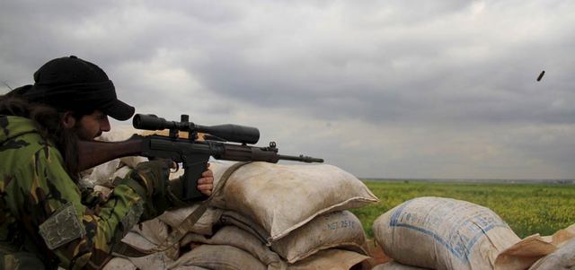 مقاتل من «الجبهة الشامية» يطلق النار عند خط المواجهة مع «داعش» في ضواحي مدينة ماري شمال حلب.  رويترز