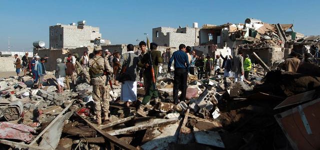 عناصر حوثية يقفون على حجم الدمار الذي خلّفته الضربات الجوية الأولى لعملية «عاصفة الحزم» حول مطار صنعاء. أ.ف.ب
