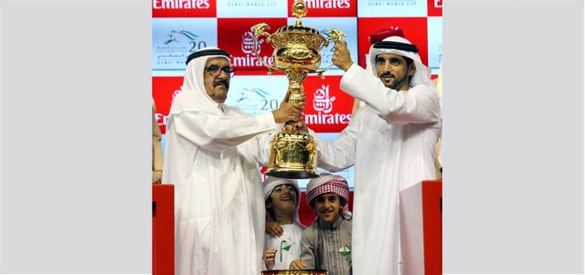 حمدان بن محمد يتسلم كأس دبي العالمي للخيول من حمدان بن راشد بعد فوز حصانه «برنس بيشوب» بلقب الشوط الرئيس. تصوير: أسامة أبوغانم