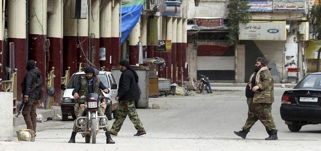 مقاتلون من المعارضة المسلحة ينتشرون في أحد شوارع مدينة إدلب لضبط الأمن بعد نحو أسبوع من سيطرتهم عليها. رويترز