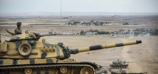 دبابات تركية تتخذ مواقع قتالية قرب الحدود السورية.  أ.ف.ب