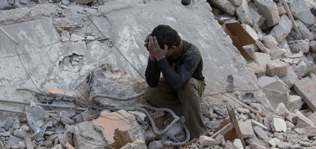 طفل سوري يبكي على أنقاض منزله.  أ.ف.ب