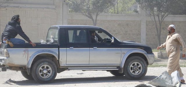 مدنيون يسعفون في شاحنة صغيرة رجلاً أصيب بغارة للقوات النظامية على بلدة سرمين بريف إدلب.  رويترز