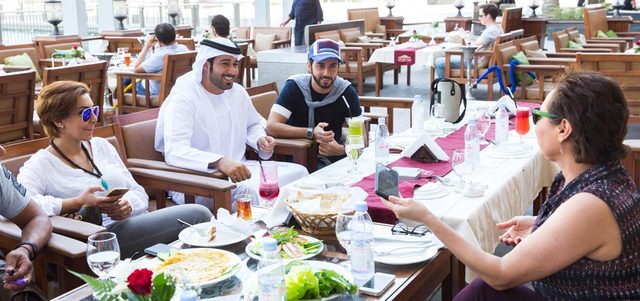 الكعبي مع زملاء وأصدقاء يتناولون الطعام. تصوير: أحمد عرديتي