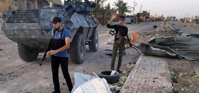 قوات الأمن العراقية ومقاتلو العشائر خلال حملة أمنية لاستعادة السيطرة على الأحياء الشمالية في الرمادي.  أ.ب