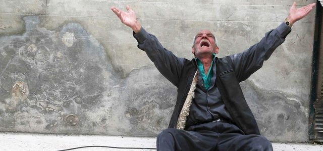 عجوز سوري يصرخ بحرقة عقب إلقاء القوات النظامية برميلاً متفجراً على حي الفردوس في حلب.  رويترز