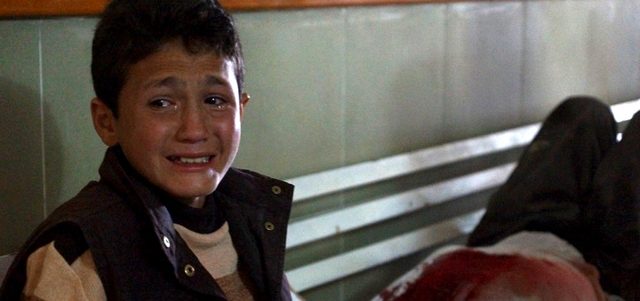 صبي سوري يبكي في مستشفى ميداني أحد أقربائه الذي أصيب في برميل متفجر ألقته القوات النظامية على ريف درعا. رويترز