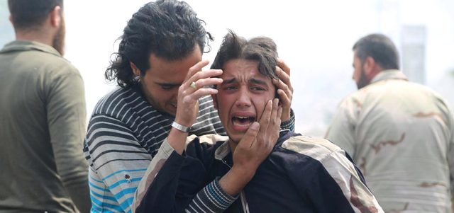 شاب يواسي أحد المسافرين في محطة للحافلات بمنطقة جسر الحج بحلب بعد تعرضها لقصف ببرميل متفجر ألقته القوات النظامية. رويترز