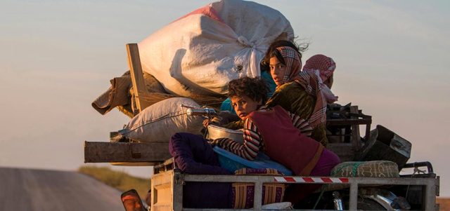 عائلة سورية تعود إلى قريتها في الريف الجنوبي لرأس العين بعد استعادة وحدات حماية الشعب الكردي السيطرة على المنطقة من «داعش». رويترز