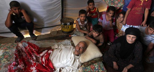 عائلة عراقية فرّت من مدينة الرمادي بعد سيطرة «داعش» عليها داخل إحدى الخيم التي نصبت لإيواء العائلات النازحة. أ.ف.ب